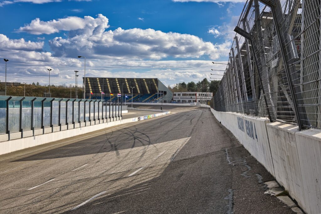 Vacant motorsport track with seating under bright skies, perfect for racing events.
