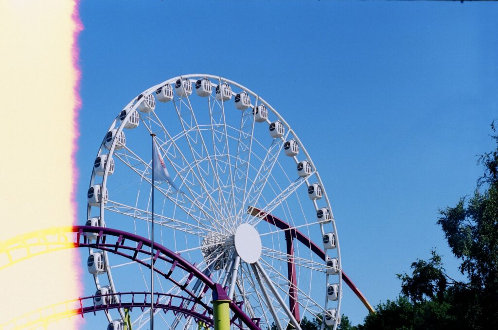 A colorful ferris wheel stands tall against a clear blue sky, capturing the essence of a fun-filled amusement park day.